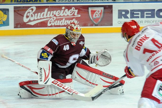 Hokejový brankář pražské Sparty Michal Neuvirth chytá střelu Radka Bonka v utkání 6. kola Tipsport extraligy 2012/13 s Oceláři Třinec.