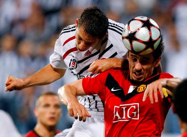 Filip Hološko (Besiktas) se snaží přeskočit Garryho Nevilla (Manchester United) v utkání Ligy mistrů.