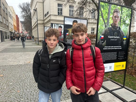 Mezi těmi, kteří se zastavovali u portrétů padlých dobrovolníků, byli také tito dva školáci. Na první fotografii je Karel Kučera, známý pod přezdívkou Charlie Czech.