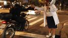 A member of the Traffic Psychologists greets a motorcyclist while performing in front of a traffic light in Sao Paulo July 23, 2012. Traffic Psychologists is a non-profit non-governmental organization which aims to humanize traffic and reduce the level of stress caused to drivers. Sao Paulo has more than 7 million vehicles, according to figures from the state transport authority Detran. Picture taken July 23, 2012. REUTERS/Nacho Doce (BRAZIL - Tags: TRANSPORT SOCIETY) Published: Čec. 24, 2012, 7:16 dop.