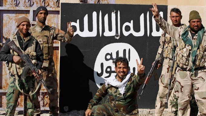 Šíitští bojovníci u vlajky Islámského státu. Ofenziva proti radikálům postupuje pomalu.