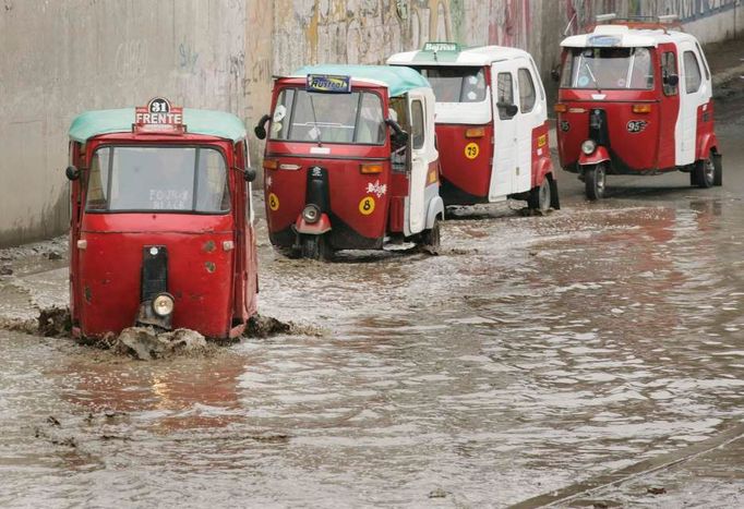 Tříkolky zvané "fototaxi" jedou zaplavenou ulicí na periferii Limy, 13. ledna 2010. Přetrvávající deště zaplavily ulice v peruánském hlavním městě.