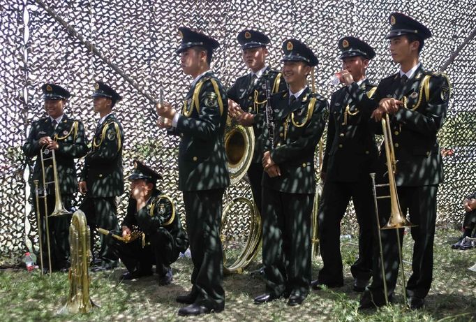 Members of a military band rest as they wait to perform before a departure ceremony for Chinese astronauts at the Jiuquan Satellite Launch Center, Gansu province June 16, 2012. China launched a spacecraft putting its first woman in orbit on Saturday as the country takes its latest step towards building a space station within the decade. A Long March rocket blasted off from the remote Jiuquan Satellite Launch Centre in China's northwestern Gobi Desert, carrying with it the Shenzhou 9 spacecraft and three astronauts, Jing Haipeng, Liu Wang and 33-year-old female fighter pilot Liu Yang. REUTERS/Jason Lee (CHINA - Tags: MILITARY SCIENCE TECHNOLOGY) Published: Čer. 16, 2012, 12:43 odp.