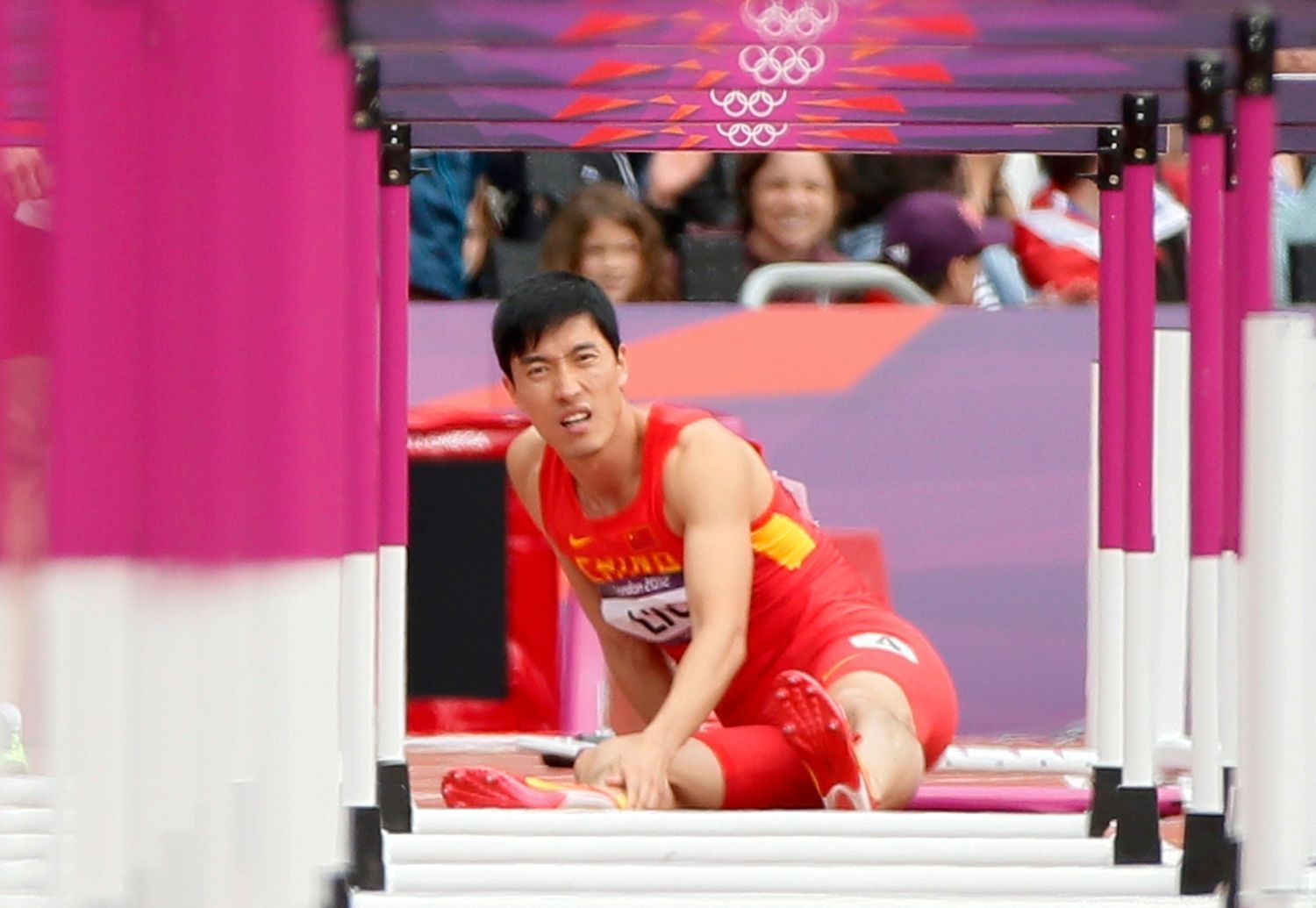 Čínský atlet Xiang Liu po pádu v disciplíně 110 metrů překážek na OH 2012 v Londýně.