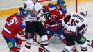 Hokejisté Jiří Hunkes (vlevo) a Michal Sersen (druhý zprava) se snaží bránit Martinse Karsumse (vpravo) v utkání KHL 2012/13 mezi Lvem Praha s Dinamem Riga.