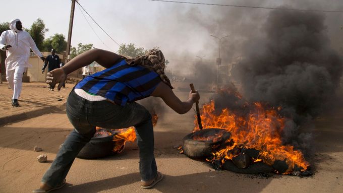 Demonstrant pálí pneumatiky při nepokojích v Niamey, 17. ledna 2015.