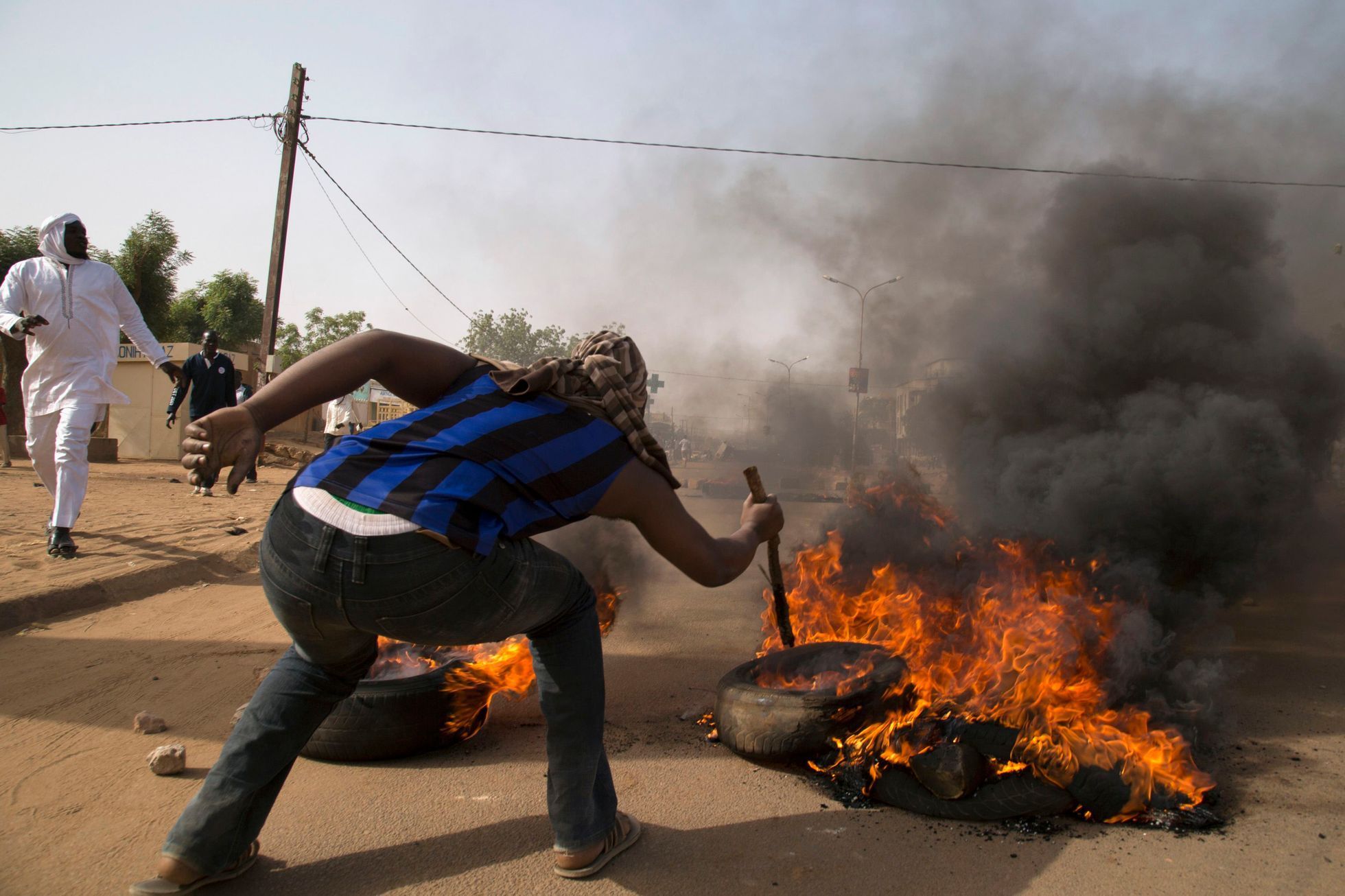 A man burns a tire during a protest against Niger President Issoufou's attendance last week at a Paris rally in support of French satirical weekly Charlie Hebdo, in Niamey