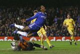 Didier Drogba (v modrém) z londýnské Chelsea padá přes brankáře Levski Sofia Božidara Mitreva v zápase Ligy mistrů.