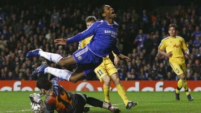 Didier Drogba (v modrém) z londýnské Chelsea padá přes brankáře Levski Sofia Božidara Mitreva v zápase Ligy mistrů.