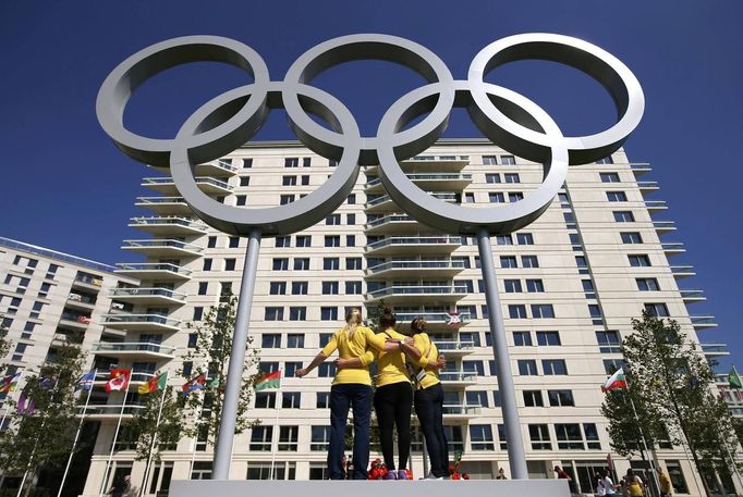 Australian swimmers pause for photos with the Olympic rings at the Athletes' Village at the Olympic Park in London, July 22, 2012. Opening ceremonies for the London 2012 Olympics will be held on Friday. REUTERS/Jae C. Hong/Pool (BRITAIN - Tags: SPORT OLYMPICS SPORT SWIMMING) Published: Čec. 22, 2012, 5:07 odp.