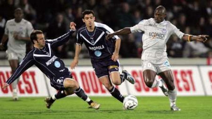Snímek ze souboje v utkání francouzské fotbalové ligy mezi Bordeaux a Toulouse. Marc Planus (vlevo) a Fernando Menegazzo z Bordeaux si "zatančili" s Achille Emanou Edzimbi s Toulouse.