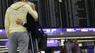 Two passengers hug each other as they look at the flight schedule board at the terminal for German air carrier Lufthansa at the Fraport airport in Frankfurt, August 31, 2012. Lufthansa passengers face widespread flight disruption from Friday after cabin crew representatives said they would start a series of strikes over pay and cost-cutting measures at Germany's largest airline. The UFO union, which represents around two-thirds of Lufthansa's 19,000 cabin crew, late on Thursday called on its members to strike from 0300 GMT to 1100 GMT on Friday in Frankfurt. REUTERS/Kai Pfaffenbach (GERMANY - Tags: BUSINESS EMPLOYMENT CIVIL UNREST TRANSPORT) Published: Srp. 31, 2012, 4:43 dop.