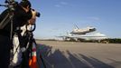 Members of the media photograph the space shuttle Discovery attached to a modified NASA 747 aircraft at Kennedy Space Center in Cape Canaveral