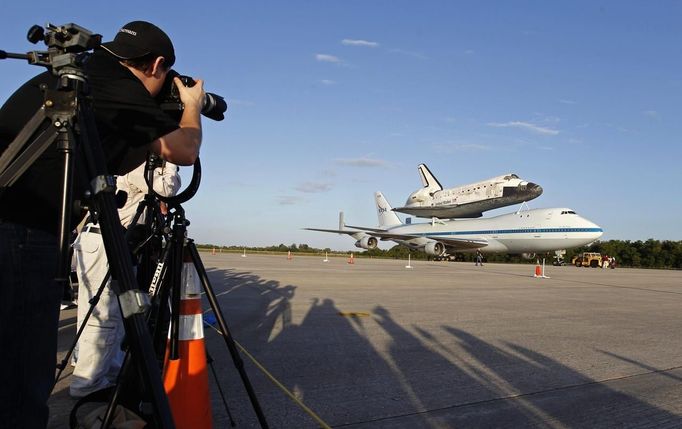 Members of the media photograph the space shuttle Discovery attached to a modified NASA 747 aircraft at Kennedy Space Center in Cape Canaveral