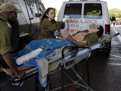 Izraelští vojáci odvážejí kolegu, zraněného na západním břehu Jordánu.