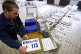 Zaměstnanec radnice v Lille připravuje volební urny a navigační cedule pro voliče.