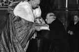 Emil Hácha v Chrámu svatého Víta líbá lebku svatého Václava v rukou kardinála Karla Kašpara. Snímek z 1. prosince 1938.
