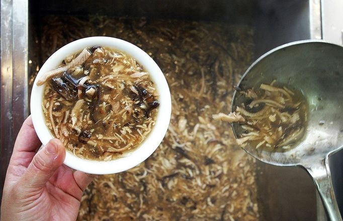 A chief serves snake soup for customers in a restaurant in Hong Kong in March 2002. Eating snakes, dogs, wild animals and insects in Asia is not considered all that extraordinary. There are a number of these foods which in some cases have become delicacies which date back many years and have now almost become traditional eating being prepared and cooked in many different ways using herbs, spices, ginger and garlic to enhance flavours. Some restaurants even have dishes of some animals as their main drawcard and is considered a normal cuisine. The Japanese love their whale meat and pufferfish, Cambodians are known to eat tarantulas-hairy spiders, while a number of other cultures incourage the eating of rats, snakes, bugs, beetles, monkeys (brains), crocodile, bats, scorpions, honey ants, grubs, embroyo eggs and many more.