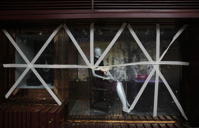 Display panels of a store at Tsim Sha Tsui shopping district are seen taped together as part of safety measures in preparation for Typhoon Vicente, in Hong Kong July 24, 2012. A severe typhoon hit Hong Kong on Tuesday, disrupting business across the financial hub, with offices and the stock market to remain closed for at least part of the morning after the city raised its highest typhoon warning overnight. REUTERS/Tyrone Siu (CHINA - Tags: ENVIRONMENT DISASTER BUSINESS) Published: Čec. 24, 2012, 3:11 dop.