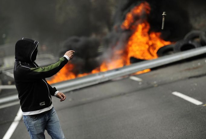 A coal miner throws a screw onto a barricade during a protest against government spending cuts in the mining sector along National Highway 630 in Cinera, northern Spanish province of Leon, June 11, 2012. REUTERS/Eloy Alonso (SPAIN - Tags: CIVIL UNREST BUSINESS EMPLOYMENT ENERGY) Published: Čer. 11, 2012, 3:55 odp.