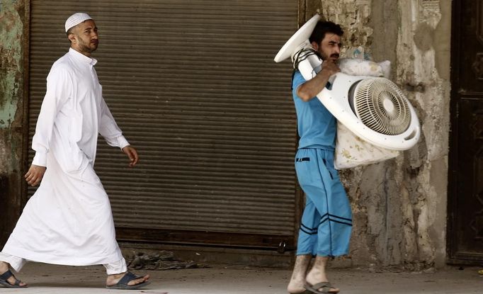 A man carries a fan as he flees Aleppo July 29, 2012. REUTERS/Zohra Bensemra (SYRIA - Tags: POLITICS CONFLICT CIVIL UNREST MILITARY) Published: Čec. 29, 2012, 5:16 odp.