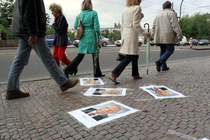 Studenti portréty prezidenta Klause vylepili na chodník před vchodem do fakulty. Někteří kolemjdoucí je obcházeli nebo alespoň překračovali.