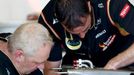 Lotus mechanics work on part of Lotus Formula One driver Romain Grosjean of France's car during the first practice session of the Australian F1 Grand Prix at the Albert P