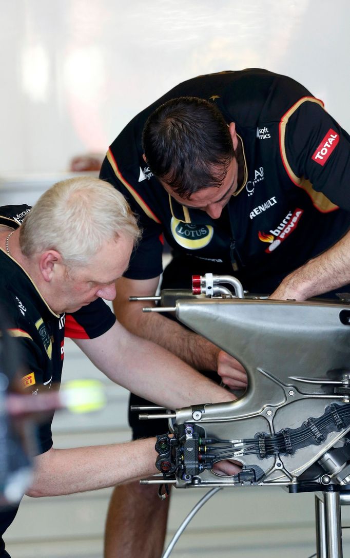 Lotus mechanics work on part of Lotus Formula One driver Romain Grosjean of France's car during the first practice session of the Australian F1 Grand Prix at the Albert P