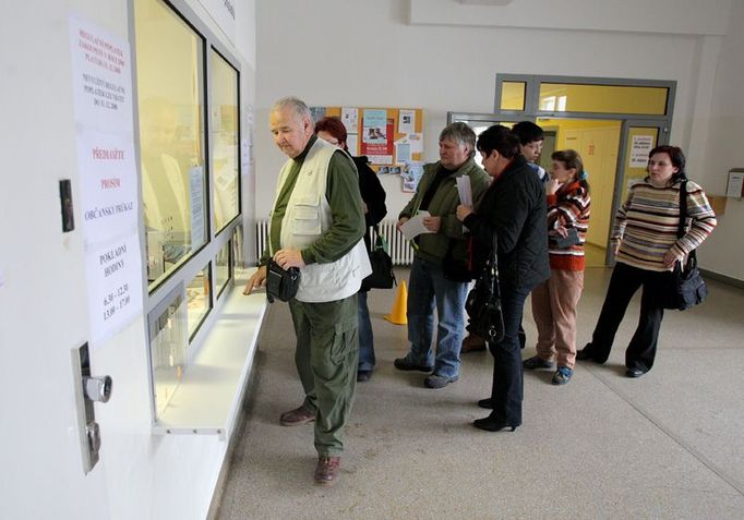 U pravého okénka se vyzvedávají darovací smlouvy. K levému okénku chodí ti, kteří chtějí poplatek uhradit hotově.