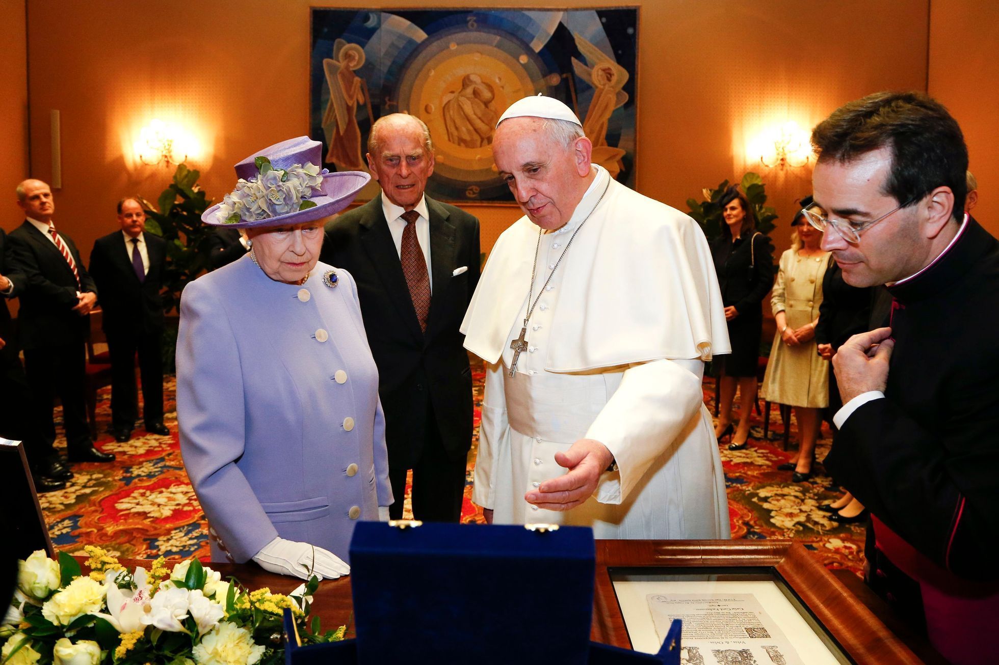 Pope Francis presents gift to Britain's Queen Elizabeth as Prince Philip looks on during a meeting at the Vatican