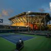 Workers use court drying equipment as Arthur Ashe Stadium is seen at sunset at the U.S. Open Championships tennis tournament in New York