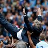 Manchester City's manager Manuel Pellegrini is thrown into the air by his team as they celebrate winning the English Premier League trophy following their soccer match against West Ham United