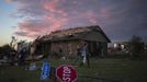 Volunteers walk past a downed street sign, after handing out food to home owners sitting in front of their house left devastated by a tornado, in Moore, Oklahoma on May 21, 2013. Rescuers went building to building in search of victims and survivors picked through the rubble of their shattered homes on Tuesday, a day after a massive tornado tore through the Oklahoma City suburb of Moore, wiping out blocks of houses and killing at least 24 people. REUTERS/Adrees Latif (UNITED STATES - Tags: DISASTER ENVIRONMENT) Published: Kvě. 22, 2013, 2:19 dop.