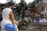 Žena pláče při pohledu na trosky svého domu u pláže Pangandaran. Po úderu obřích vln postrádá členy své rodiny.