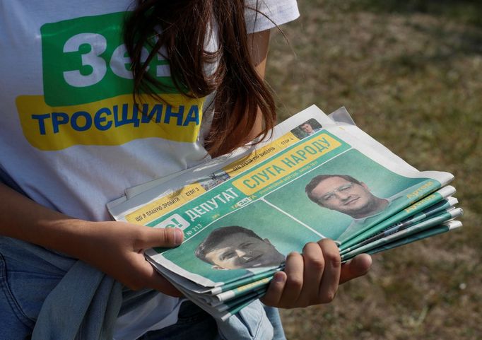 A volunteer holds electoral materials in support of the Servant of the People party led by Ukrainian President Volodymyr Zelenskiy during an event ahead of the parliament