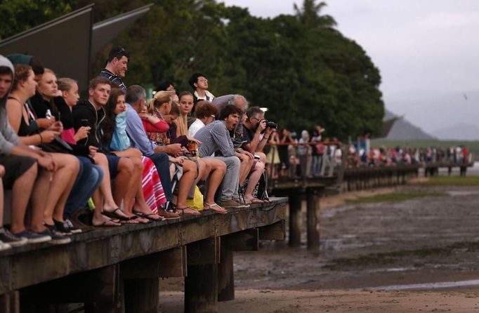 Tourists look at a cloudy sky as a full solar eclipse begins in the northern Australian city of Cairns November 14, 2012. REUTERS/Tim Wimborne (AUSTRALIA - Tags: SOCIETY ENVIRONMENT) Published: Lis. 13, 2012, 9:33 odp.