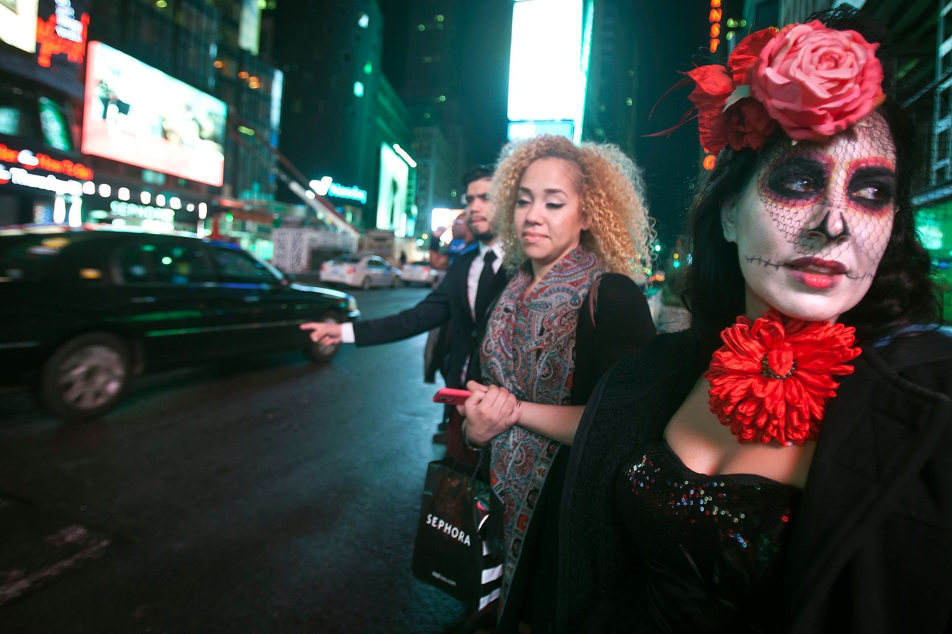 Halloween reveller Cara Chiarelli and her friends try to hail a taxi in Times Square early in the morning in the Manhattan borough of New York