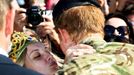 Britain's Prince Harry receives a kiss from a woman carrying a 'Marry Me' banner during his visit to Sydney's Opera House in Australia