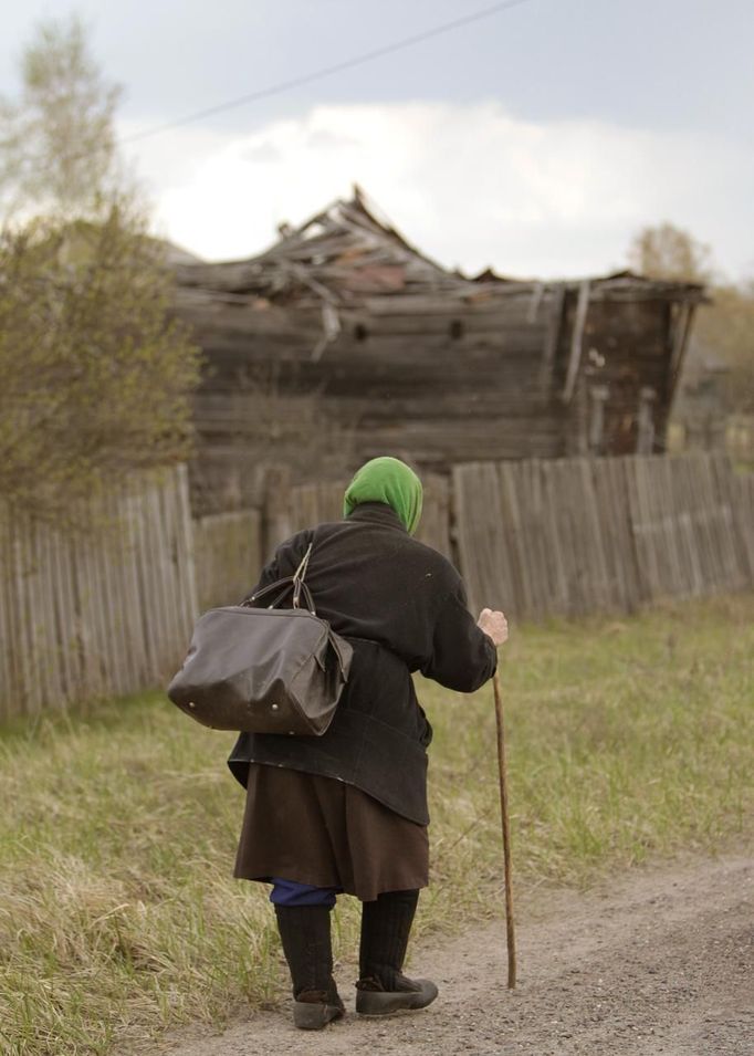 An elderly woman walks after purchasing products from a mobile shop on the eve of Radunitsa in the abandoned village of Tulgovichi