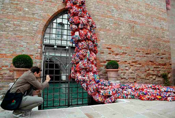 A visitor takes a picture of part of an installation called "The Garbage Patch State" by Italian artist Maria Cristina Finucci