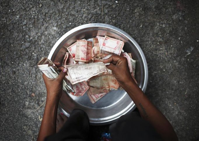 Drumpal Choudhary, 11, a street performer counts the money that he received for taking part in a street performance in Kathmandu August 15, 2012. Drumpal, his brother, Gchan and sister, Shivani, came to Kathmandu from India 5 years ago. They earn their living by performing tricks on the streets of Kathmandu. According to Drumpal they earn around $10 a day by performing tricks, which is not enough to feed their 10-member family living together in a small hut without a proper toilet or any basic needs. REUTERS/Navesh Chitrakar (NEPAL - Tags: SOCIETY POVERTY IMMIGRATION) Published: Srp. 15, 2012, 4:43 odp.