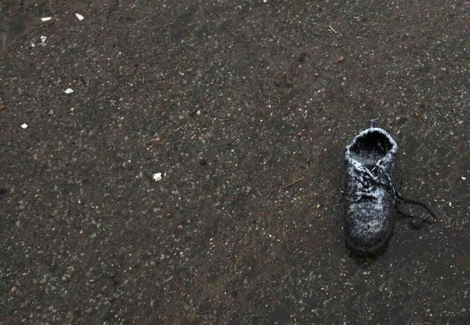 A shoe left on a street by Hurricane Sandy is seen covered in snow from nor'easter, also known as a northeaster storm in Lindenhurst, New York November 7, 2012. The wintery nor'easter storm added misery to thousands of people whose homes were destroyed by superstorm Sandy, which killed 120 people when it smashed ashore on October 29 in the New York-New Jersey area, swallowing entire neighborhoods with rising seawater and blowing homes from their foundations. REUTERS/Lucas Jackson (UNITED STATES - Tags: DISASTER ENVIRONMENT) Published: Lis. 7, 2012, 9:01 odp.