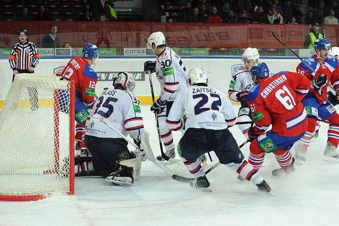 Hokejisté Lva Praha Jiří Novotný (vlevo) a Erik Christensen se snaží prosadit proti brankáři Jeffu Glassovi, Alexandru Nikulinovi a Nikitovi Zajcevovi v KHL proti Sibiru.