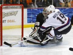 Gólman Jean-Sebastien Giguere při úspěšném zákroku proti útočníkovi Vancouveru Canucks Marcusi Näslundovi.