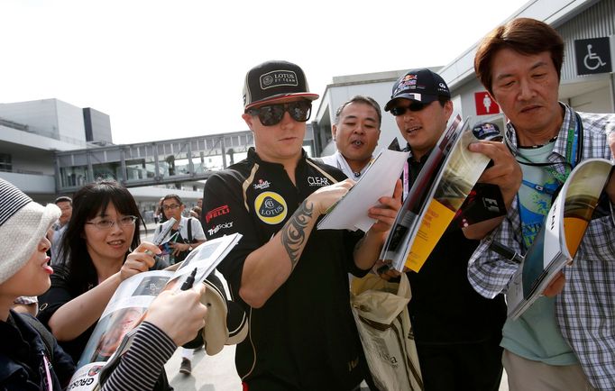 Finský pilot F1 Kimi Räikkönen rozdává autogramy při kvalifikaci na VC Japonska 2012 v Suzuce.