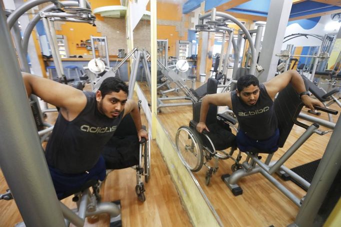 Wheelchair-bound Palestinian freelance photographer Moamen Qreiqea is reflected in a mirror as he exercises in a gym in Gaza City October 1, 2012. Qreiqea, 25, lost both his legs in an Israeli air strike in 2008 while taking pictures east of Gaza. The father of two is determined to continue his career despite his disability. REUTERS/Suhaib Salem (GAZA - Tags: MEDIA SOCIETY) Published: Říj. 1, 2012, 3:39 odp.