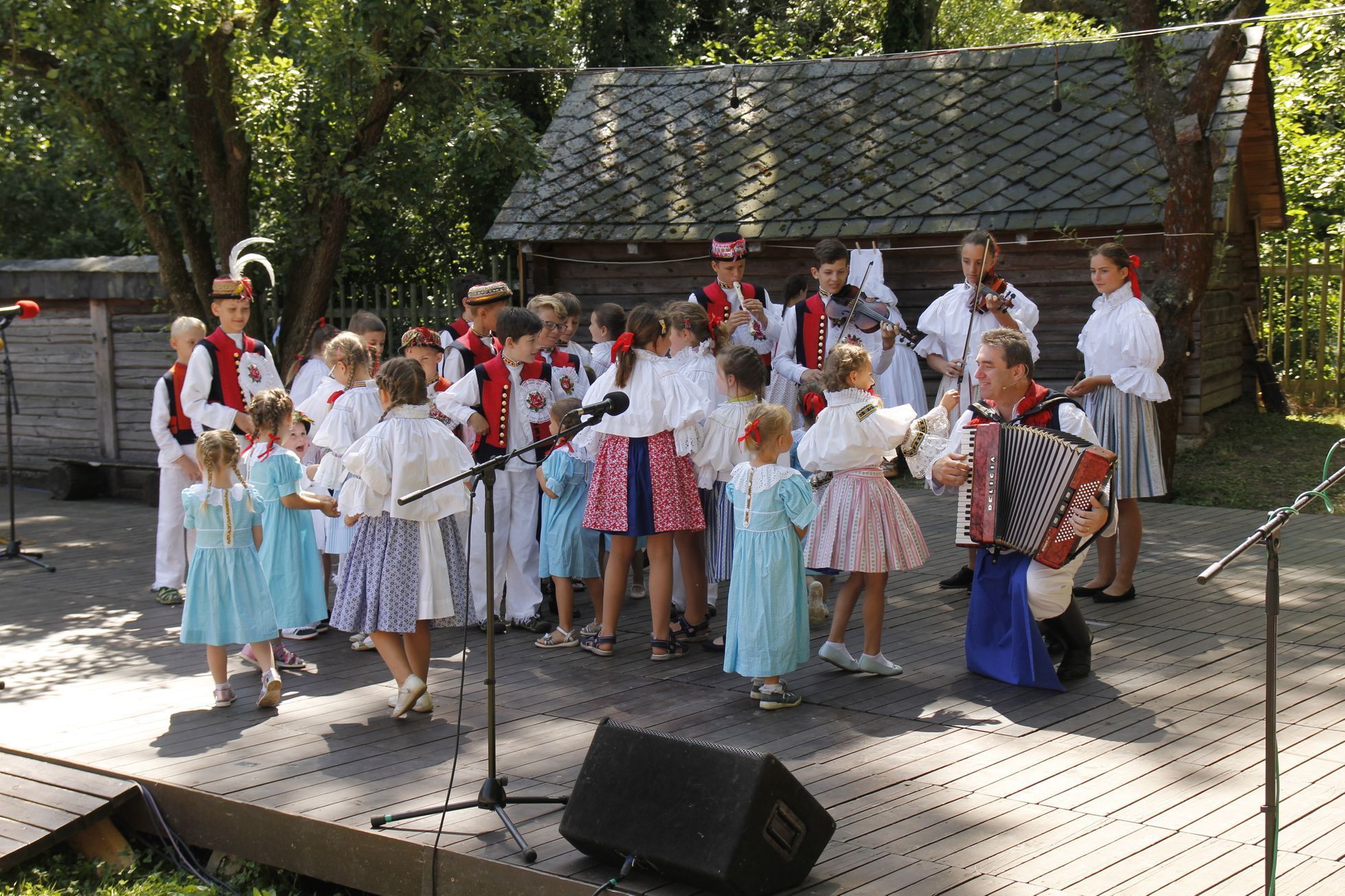 Učitel Vlastinil Ondra s harmonikou a s dětmi ze svého folklorního souboru Nivnička na folklorním festivalu ve Strážnici, odkud si v minulosti odvezli jednu z hlavních cen