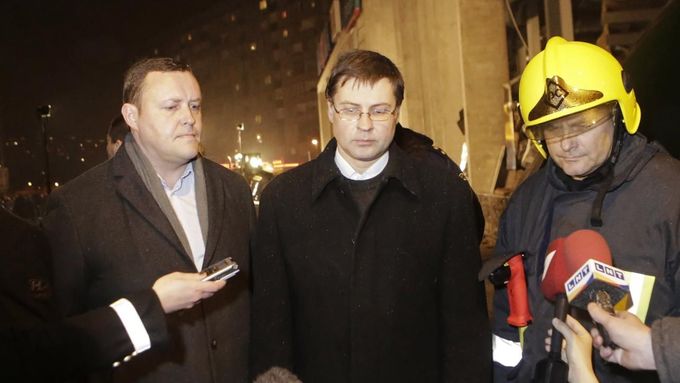 Premiér Valdis Dombrovskis (uprostřed) u zříceného obchodního centra v Rize. Vlevo ministr vnitra Richards Kozlovskis.