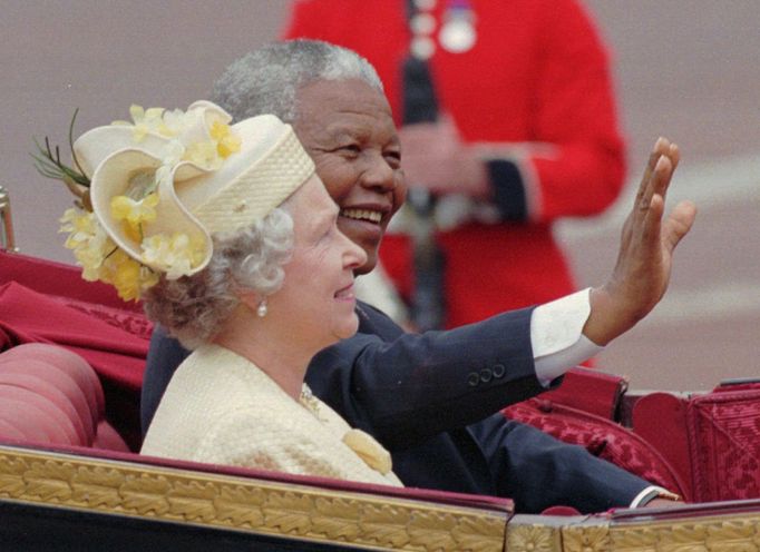 This is a Tuesday July 9 1996 file photo of South African President Nelson Mandela as he waves to crowds as he sits next to Queen Elizabeth II in a an open carriage on th