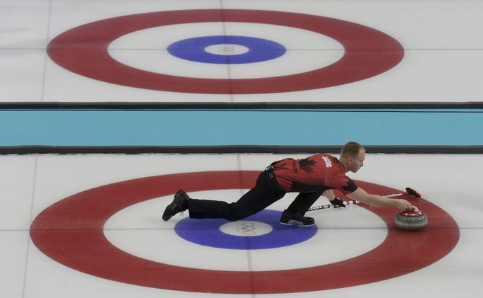 Canada's skip Brad Jacobs delivers the stone during their men's curling round robin game against Switzerland at the 2014 Sochi Olympics in the Ice Cube Curling Center in